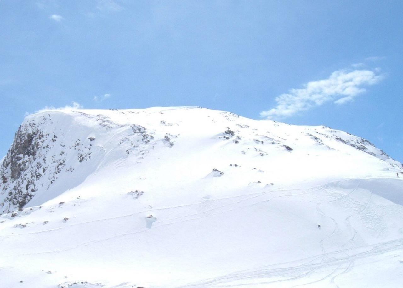 A skier moving across a snow-covered slope in the Alps