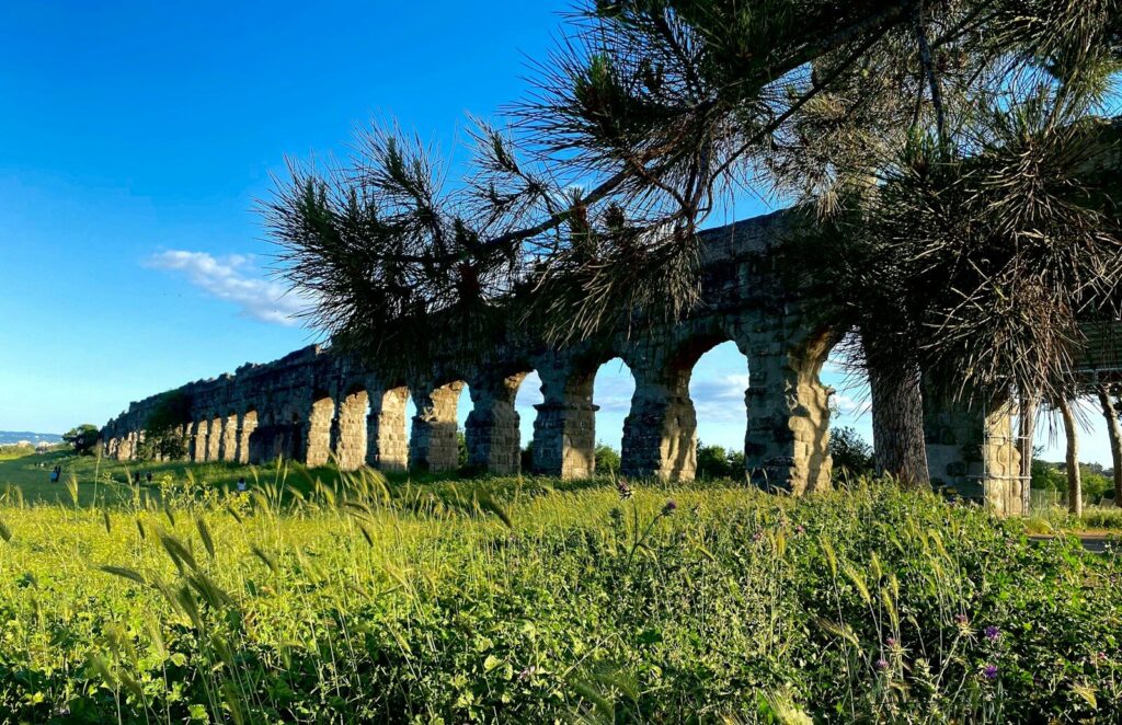 an old stone building with arches in the middle of a field